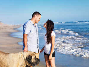 Couple and dog happy on the beach because they invested in Seaside Park real estate
