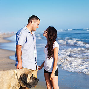 Couple and dog happy on the beach because they invested in Seaside Park real estate
